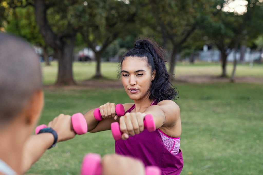 Fitness Goals Determined fitness woman using dumbbells