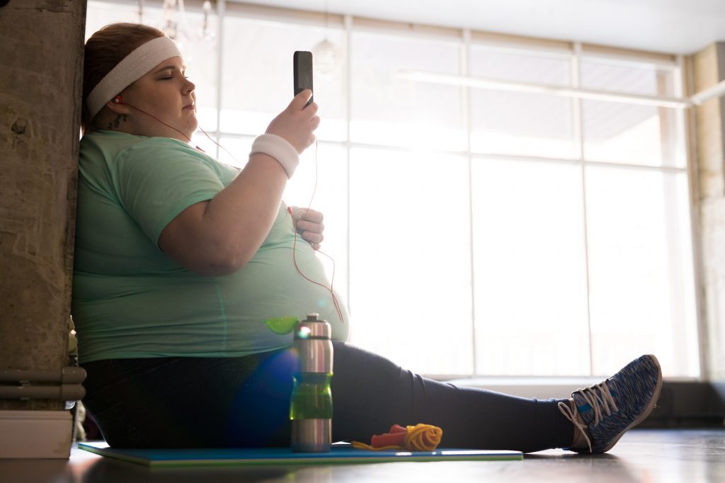 Obese Woman Using Smartphone after Workout