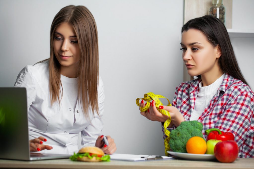 weight loss professional help Young woman visiting nutritionist in weight loss clinic